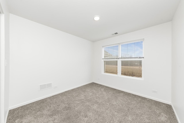 spare room featuring baseboards, visible vents, and carpet flooring