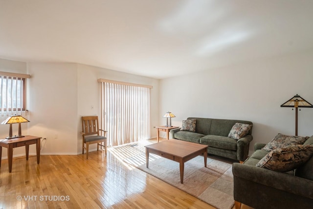 living room with baseboards and light wood-style floors