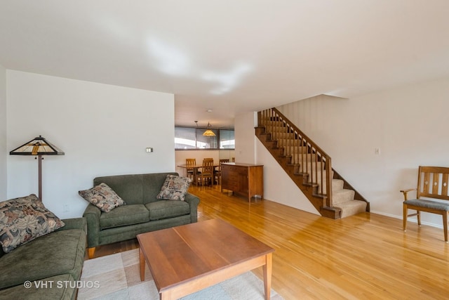 living room featuring stairway and light wood-type flooring