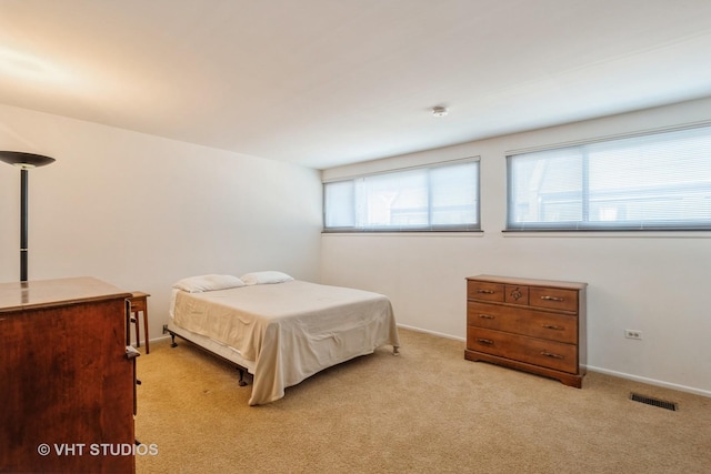 bedroom with visible vents, baseboards, and light colored carpet