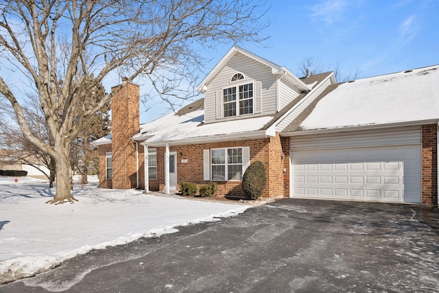 view of front of home featuring driveway, brick siding, and an attached garage