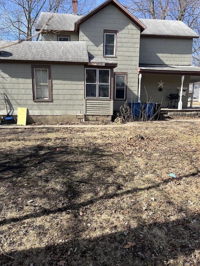 back of property featuring a shingled roof