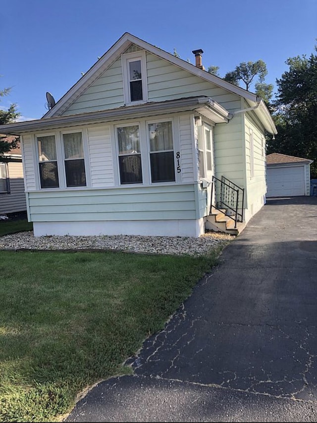 bungalow-style home featuring an outbuilding and a front yard