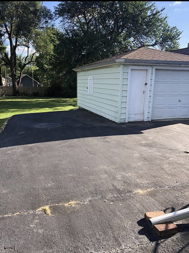 detached garage featuring fence