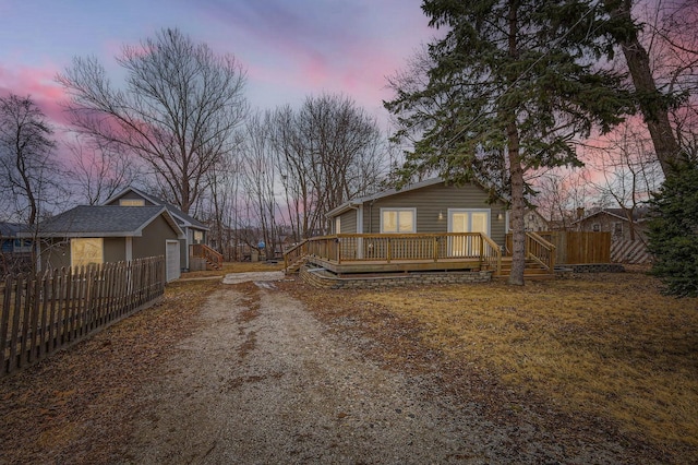 exterior space with a deck, dirt driveway, and fence