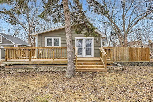 rear view of house featuring fence and a wooden deck