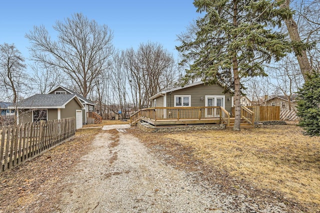 view of property exterior with a garage, french doors, fence, and a wooden deck