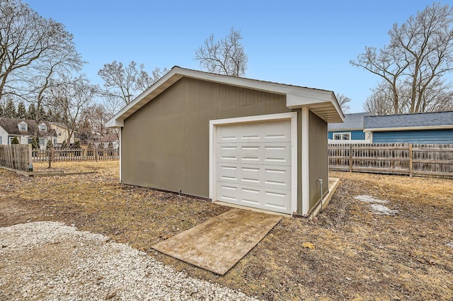 detached garage featuring fence