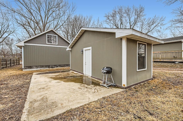 view of outdoor structure featuring fence and an outbuilding