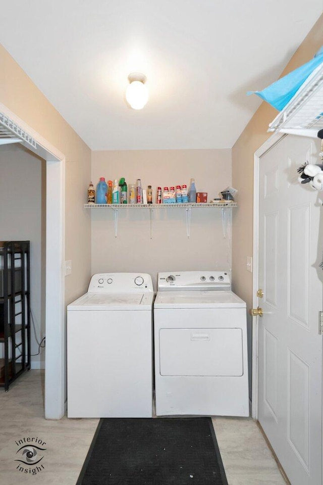 laundry area with laundry area, separate washer and dryer, and light wood finished floors