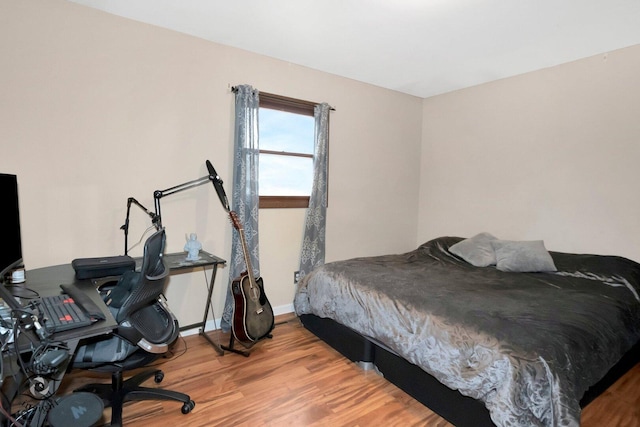 bedroom with baseboards and wood finished floors