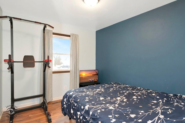 bedroom with baseboards and wood finished floors