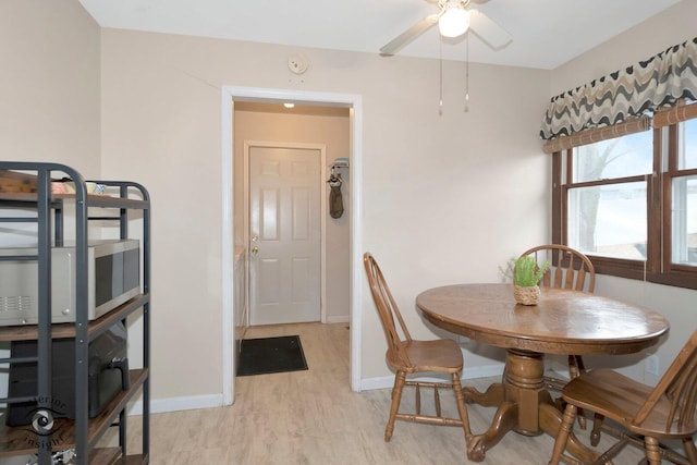 dining area featuring ceiling fan, light wood-type flooring, and baseboards