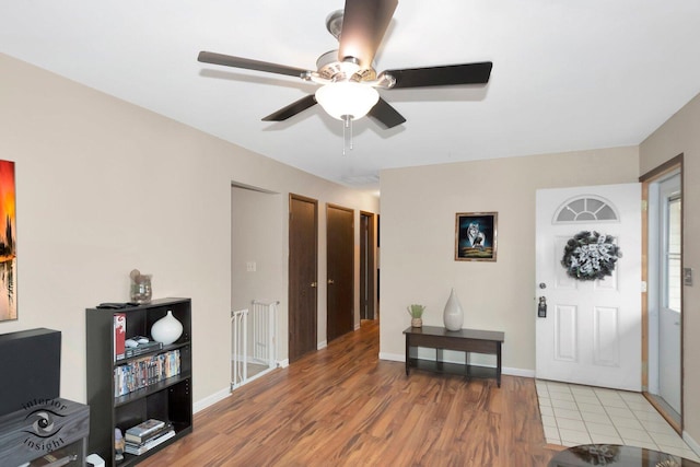 entryway featuring a ceiling fan, light wood-style flooring, and baseboards