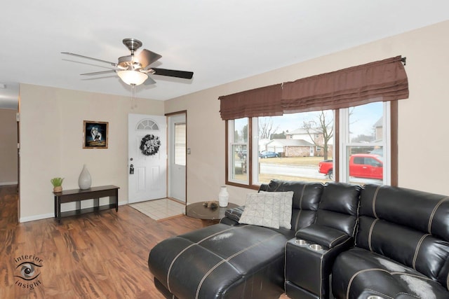 living room featuring ceiling fan, baseboards, and wood finished floors