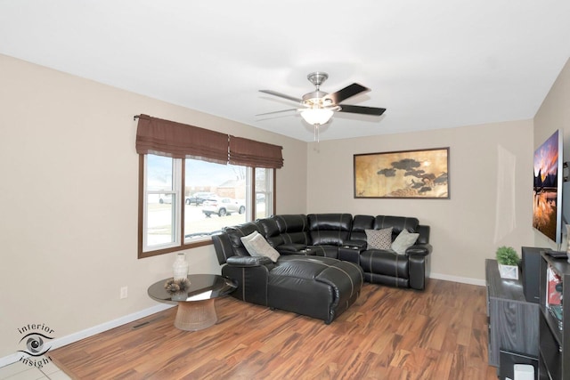 living area with ceiling fan, baseboards, and wood finished floors