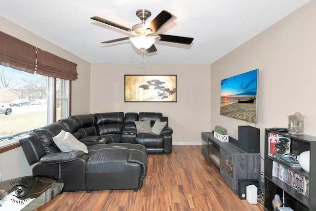 living room with ceiling fan, baseboards, and wood finished floors