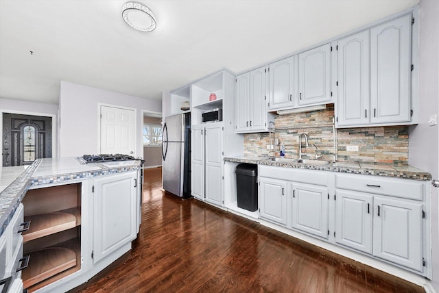 kitchen featuring dark wood-style floors, open shelves, appliances with stainless steel finishes, white cabinets, and a sink