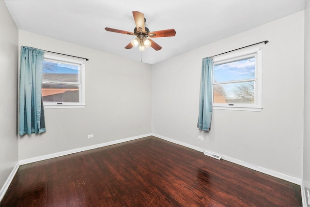 empty room with a healthy amount of sunlight, visible vents, and wood finished floors