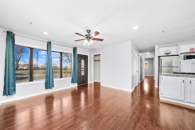 unfurnished living room with baseboards, visible vents, ceiling fan, wood finished floors, and recessed lighting