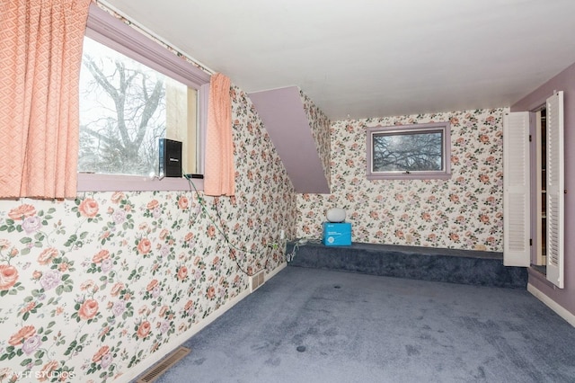 interior space featuring wallpapered walls, carpet flooring, baseboards, and visible vents