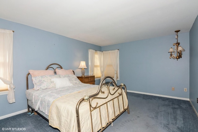 carpeted bedroom featuring multiple windows and baseboards