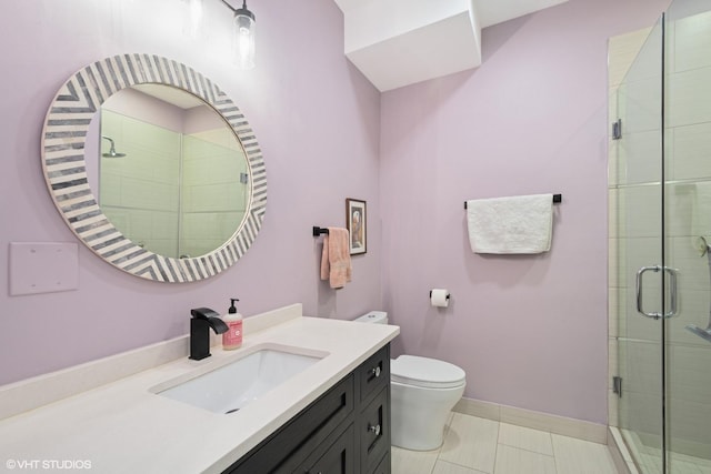 bathroom featuring toilet, a stall shower, vanity, baseboards, and tile patterned floors