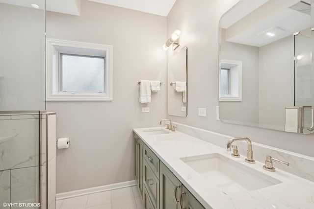 full bath with double vanity, baseboards, a sink, and tile patterned floors