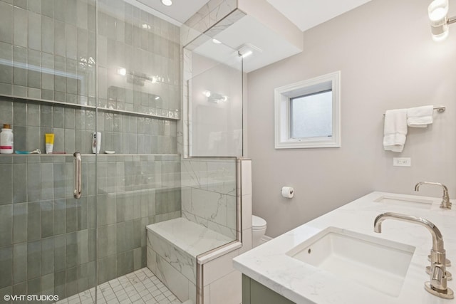 full bathroom featuring double vanity, a sink, and tiled shower