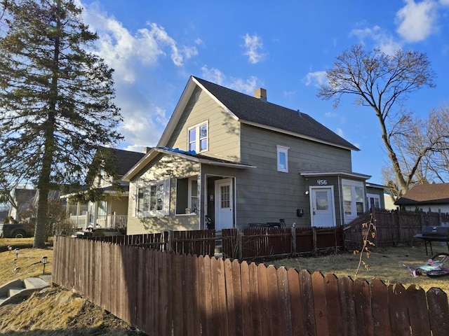 view of front of house featuring a fenced front yard and a chimney