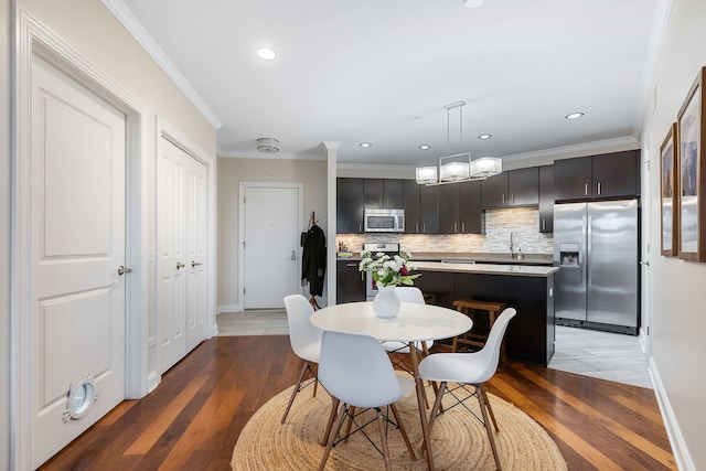 dining space with recessed lighting, ornamental molding, light wood-style floors, a chandelier, and baseboards