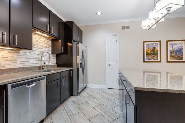 kitchen featuring visible vents, backsplash, appliances with stainless steel finishes, ornamental molding, and a sink