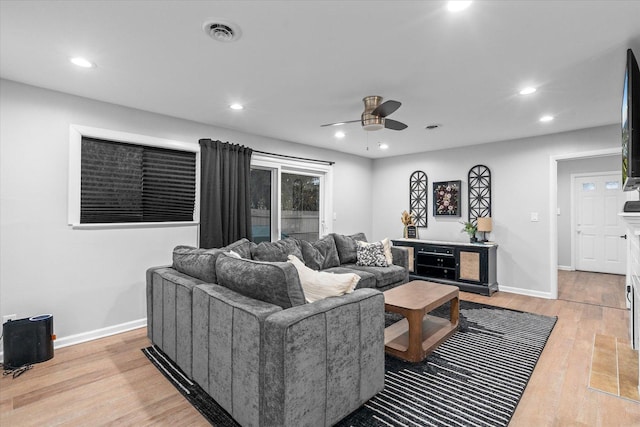 living area with light wood-type flooring, visible vents, baseboards, and recessed lighting