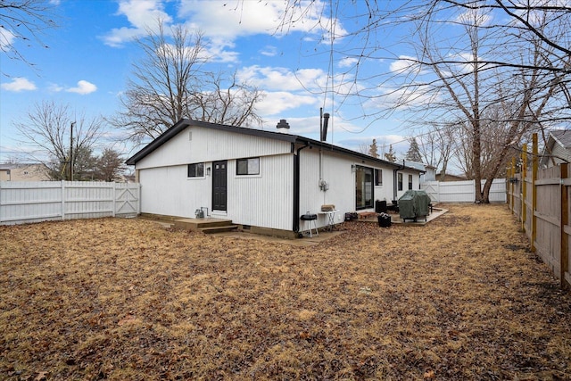 back of house with a fenced backyard