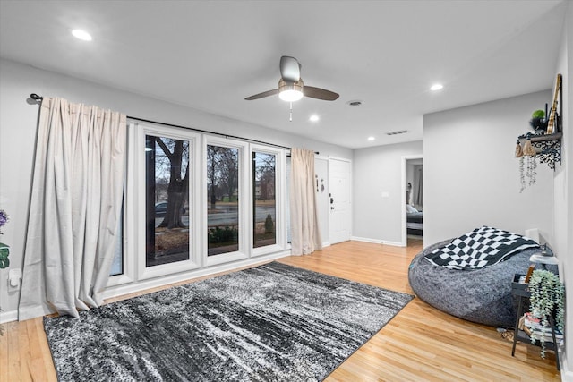 living area featuring light wood-type flooring, visible vents, and recessed lighting