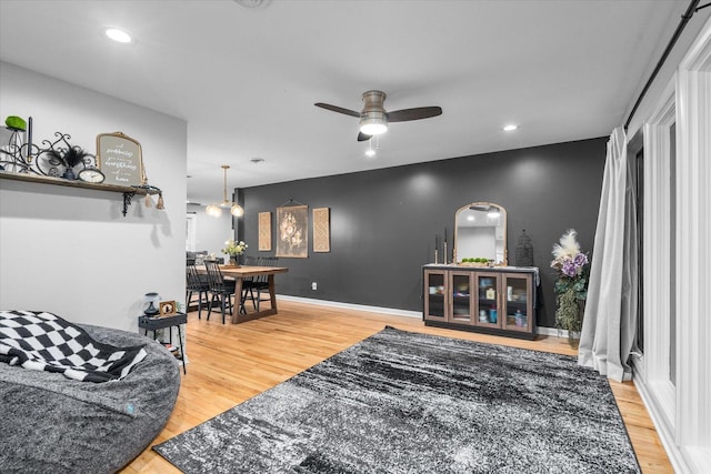 living area featuring arched walkways, wood finished floors, a ceiling fan, and recessed lighting