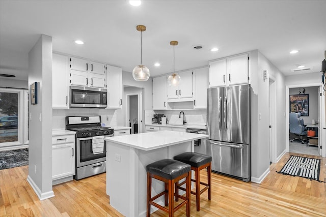 kitchen featuring light countertops, appliances with stainless steel finishes, and white cabinets