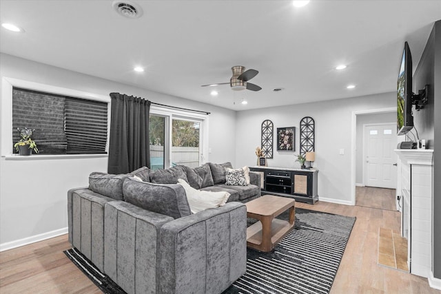 living area featuring baseboards, recessed lighting, visible vents, and light wood-style floors