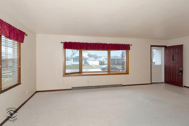 empty room with baseboards, a baseboard radiator, and light colored carpet