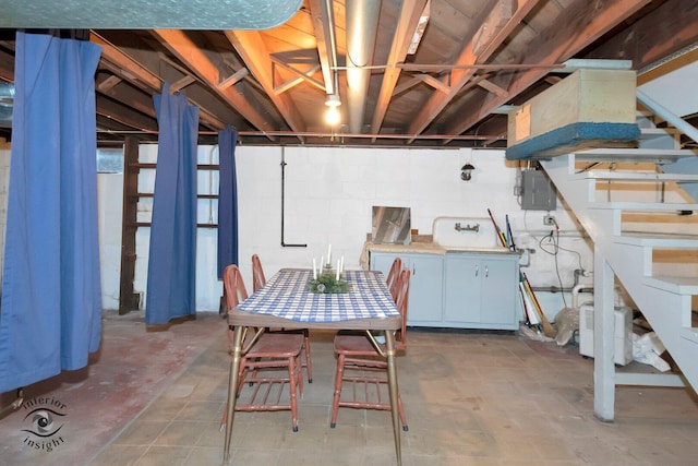 unfinished basement with concrete block wall and electric panel