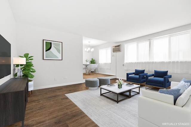 living area with baseboards, a chandelier, an AC wall unit, and wood finished floors