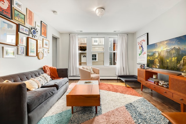 living room with wood finished floors, visible vents, and a baseboard radiator