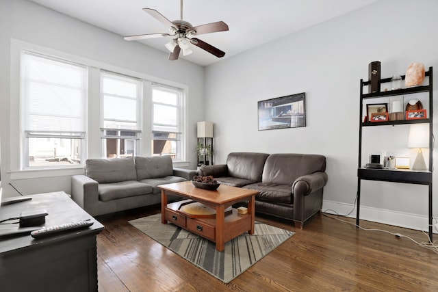 living room with baseboards, plenty of natural light, a ceiling fan, and dark wood-style flooring