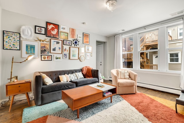 living room featuring a baseboard radiator, visible vents, and wood finished floors