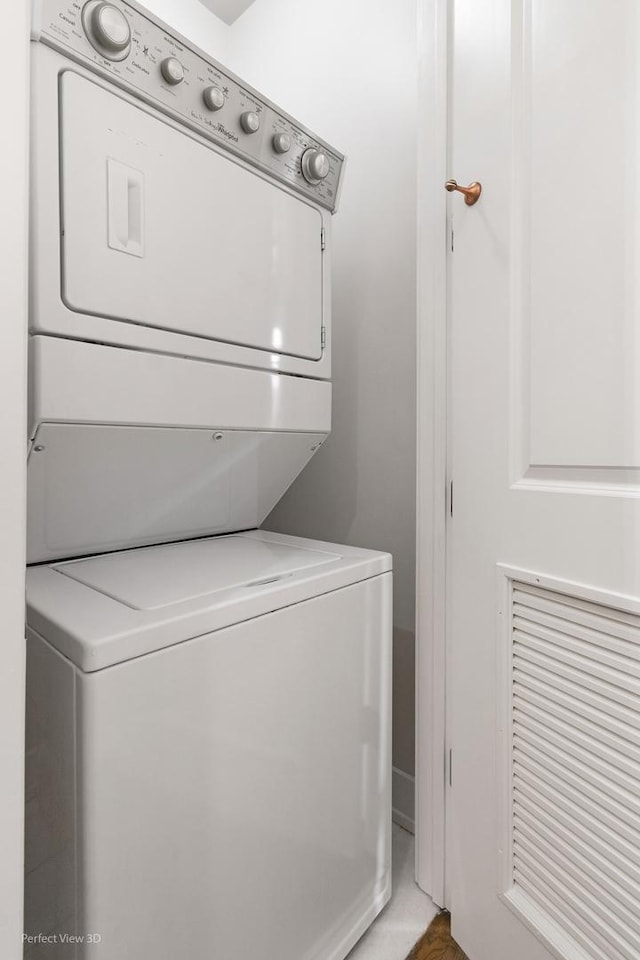 clothes washing area with stacked washer and clothes dryer