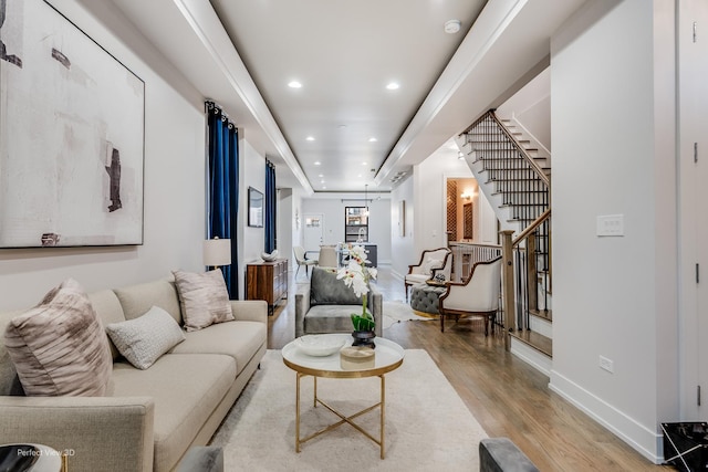 living area featuring light wood-type flooring, baseboards, recessed lighting, and stairs