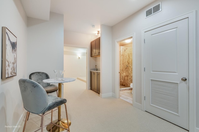 interior space featuring light colored carpet, visible vents, and baseboards