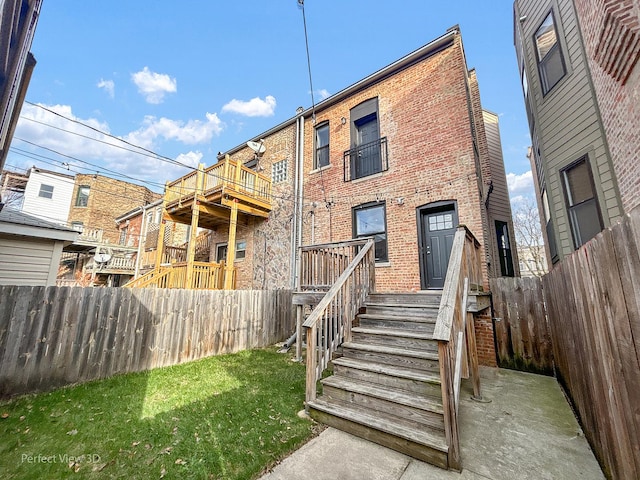 back of property with a yard, a fenced backyard, and brick siding