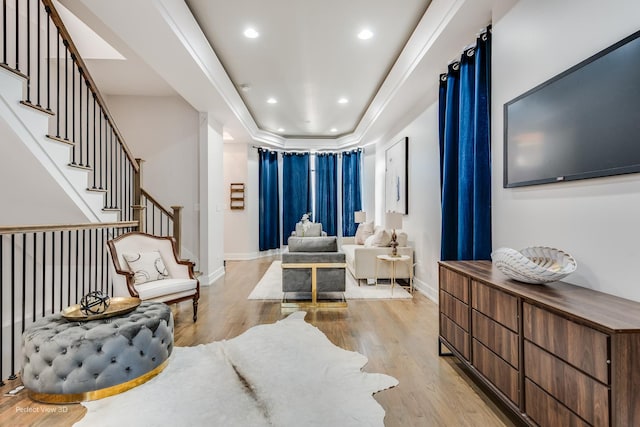 living area with recessed lighting, light wood-style flooring, baseboards, and stairs