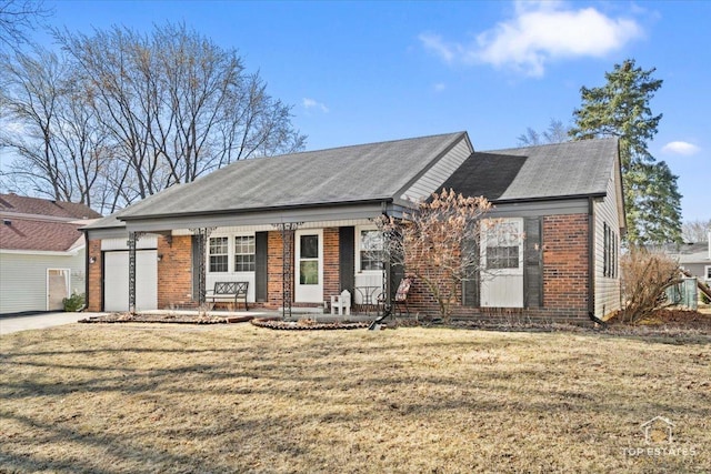 view of front of house featuring brick siding, a porch, a front yard, and a garage